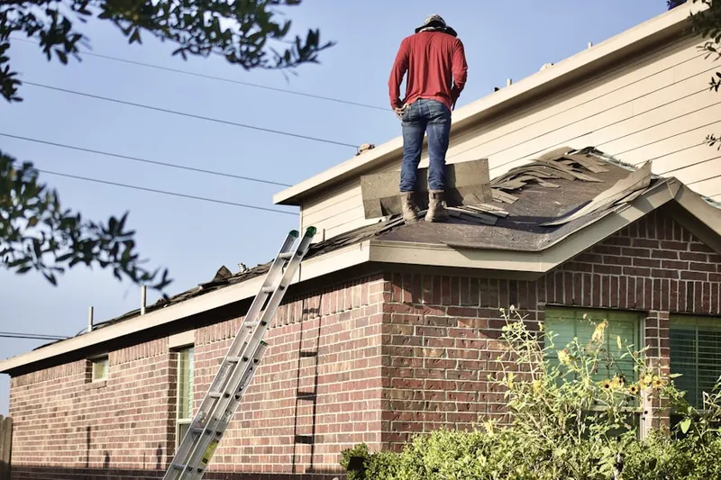 Professional roofer working on a residential roof in Hartly